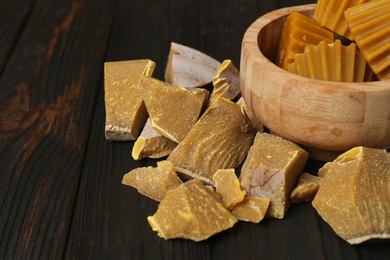 Photo of Different natural beeswax blocks on wooden table. Space for text