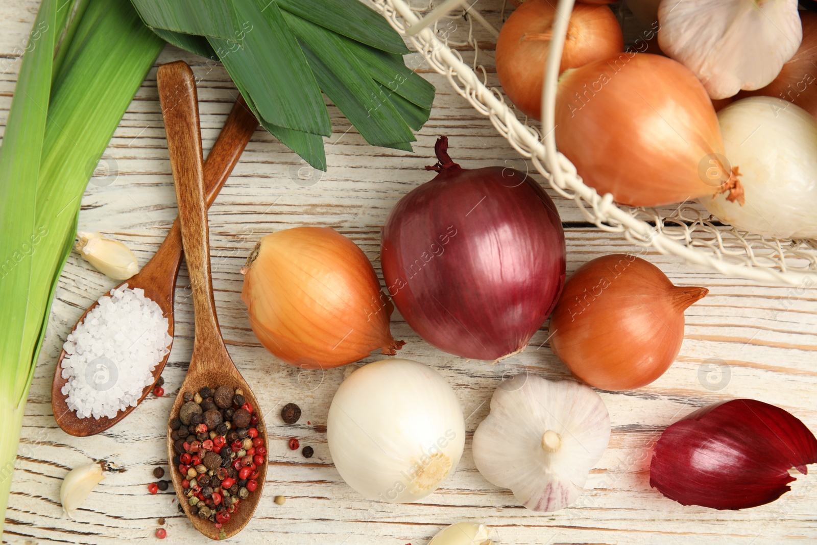Photo of Fresh onion bulbs, leek, garlic, peppers mix and salt on white wooden table, flat lay