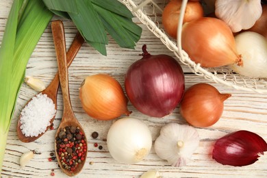 Fresh onion bulbs, leek, garlic, peppers mix and salt on white wooden table, flat lay