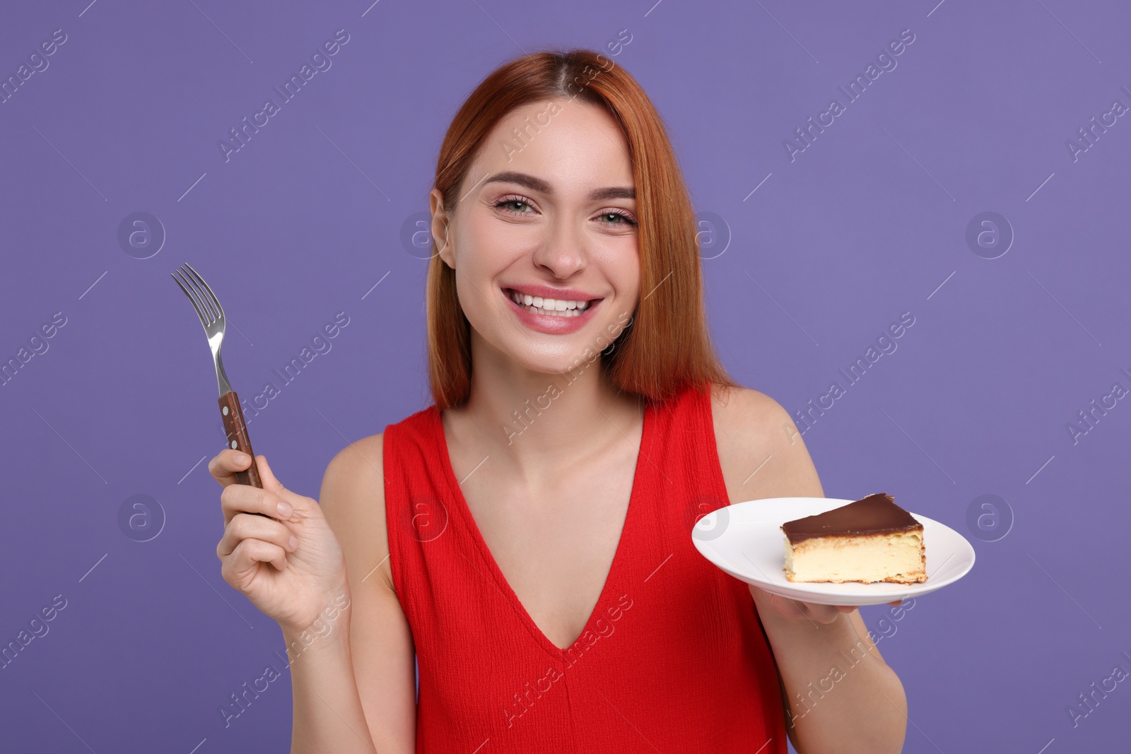 Photo of Young woman with piece of tasty cake on purple background