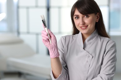 Photo of Cosmetologist with cosmetic brush in clinic, space for text