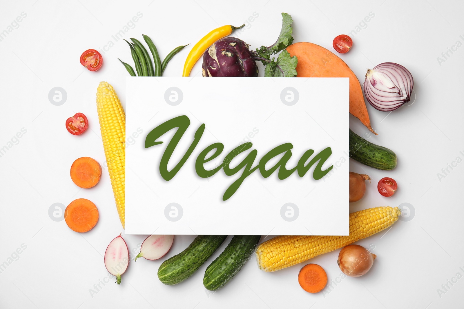 Image of Paper card with word Vegan and fresh vegetables on white background, flat lay