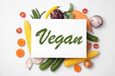 Paper card with word Vegan and fresh vegetables on white background, flat lay