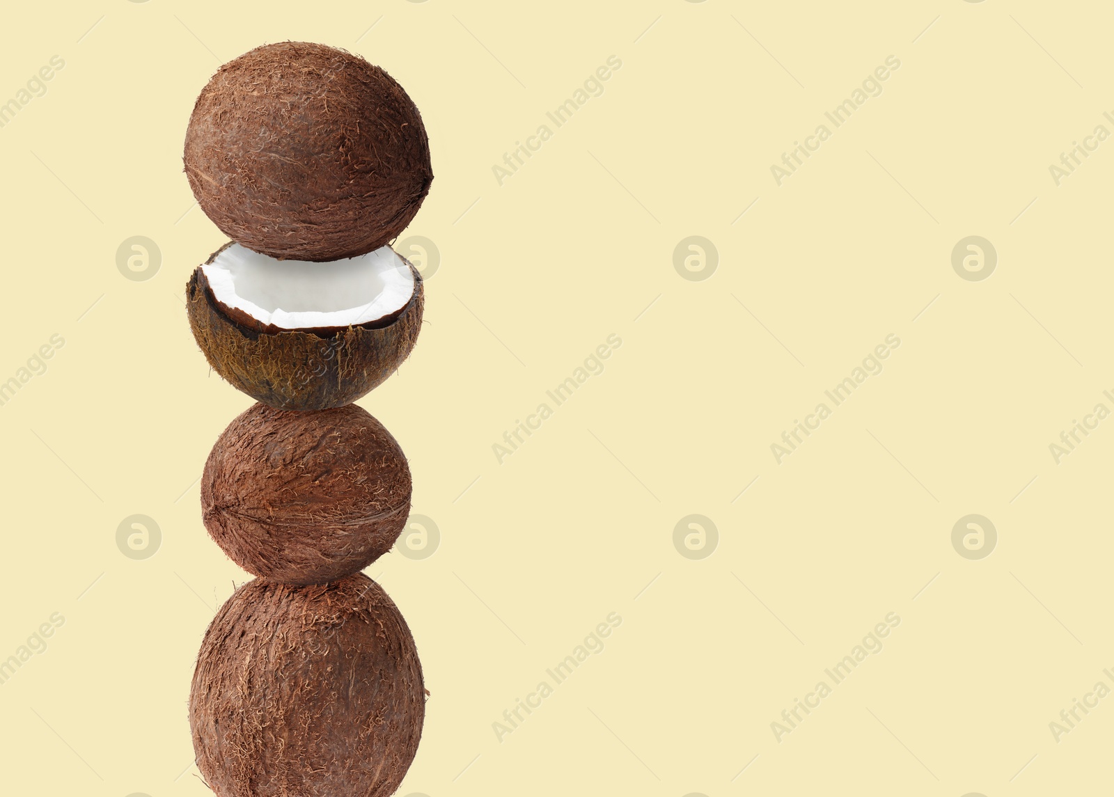 Image of Stack of fresh coconuts on beige background. Space for text