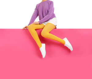 Photo of Woman wearing yellow tights and stylish shoes sitting on color background, closeup