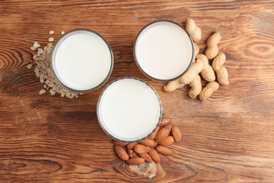 Glasses with different types of milk on wooden background