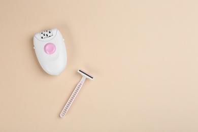 Photo of Modern epilator and razor on beige background, flat lay. Space for text