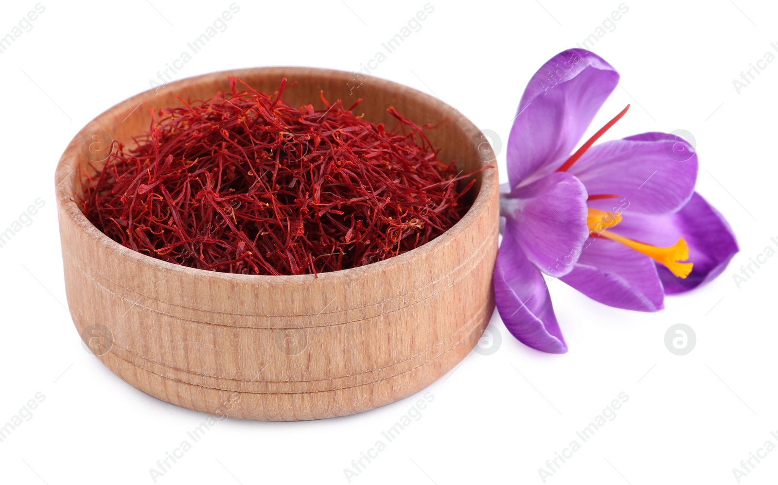 Photo of Dried saffron in wooden bowl and crocus flower on white background