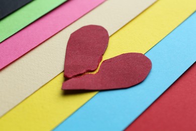 Photo of Halves of torn paper heart on colorful background, closeup. Breakup concept