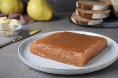 Photo of Delicious quince paste on grey table, closeup