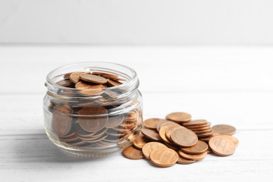 Glass jar and coins on table. Space for text