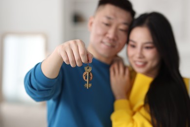 Photo of Happy couple with key in their new apartment, selective focus