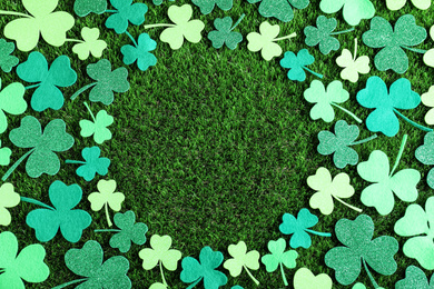 Frame made of clover leaves on green grass, flat lay with space for text. St. Patrick's Day celebration