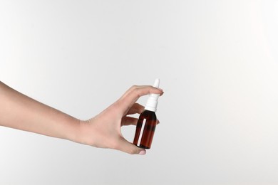 Photo of Woman holding nasal spray on white background, closeup