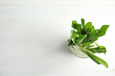 Photo of Glass of wild garlic or ramson on white wooden table, top view with space for text
