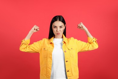 Photo of Strong woman as symbol of girl power on red background. 8 March concept