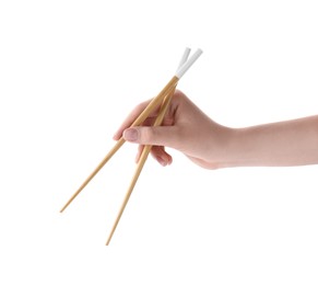 Woman holding pair of wooden chopsticks on white background, closeup