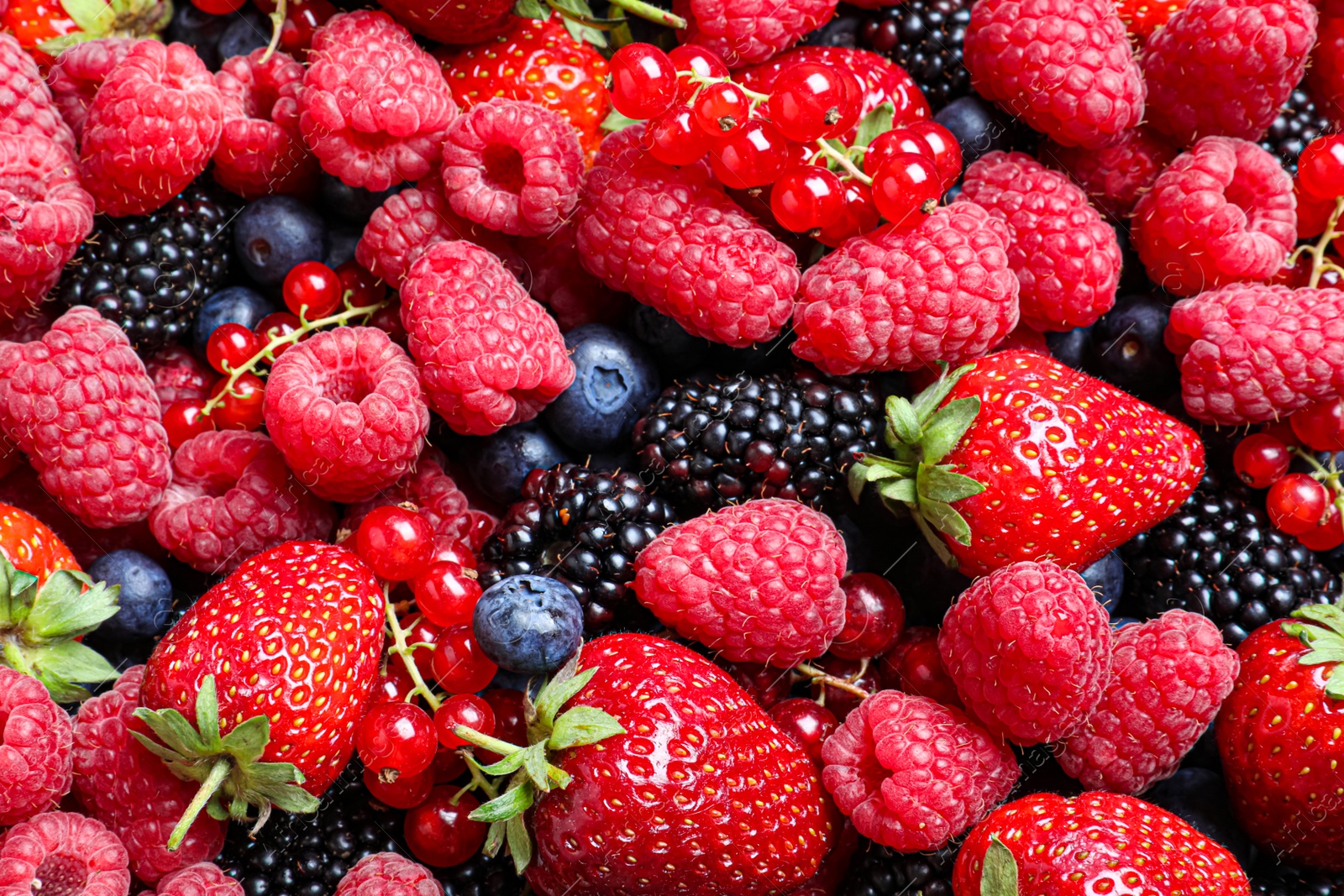 Photo of Mix of different ripe tasty berries as background, top view