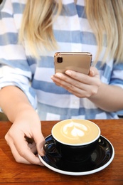 Photo of Blogger taking photo of coffee at cafe, closeup