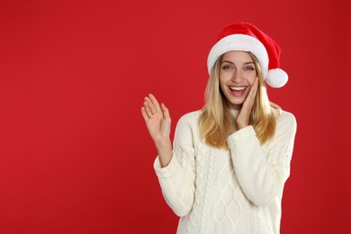 Photo of Happy woman in Santa hat on red background, space for text. Christmas countdown