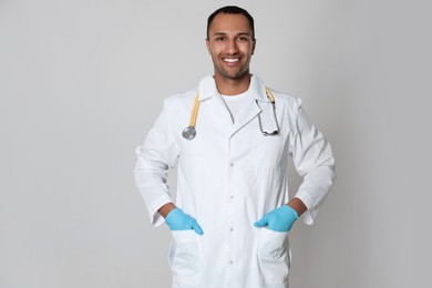 Photo of Doctor or medical assistant (male nurse) in uniform with stethoscope on light grey background