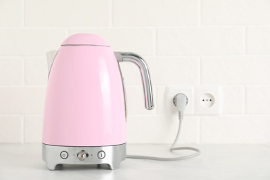 Photo of Modern electric kettle on counter in kitchen