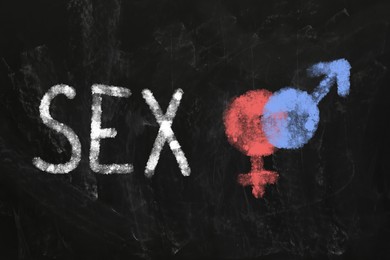 Sexual education. Chalked word Sex, female and male gender signs on blackboard