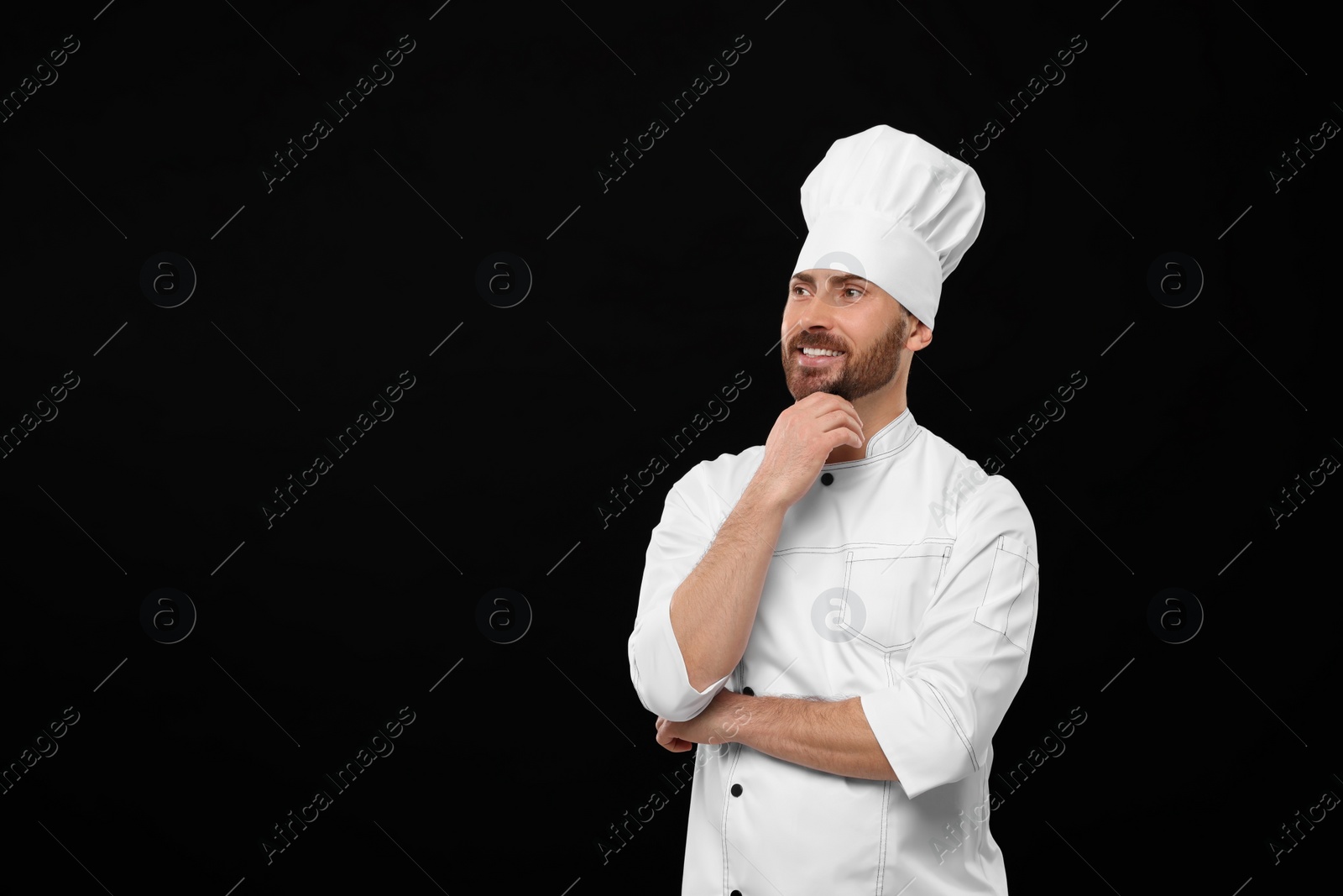 Photo of Smiling mature chef on black background, space for text