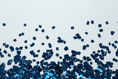 Photo of Shiny blue confetti on light grey background, flat lay