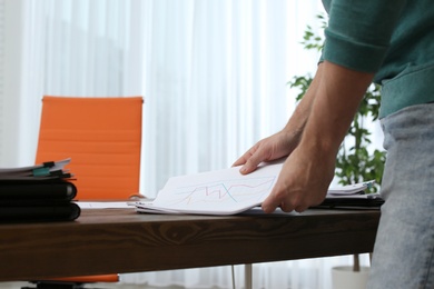 Photo of Businessman working with documents at office table, closeup