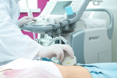 Doctor conducting ultrasound examination of internal organs in clinic, closeup