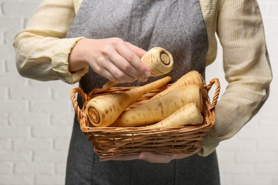 Photo of Woman with fresh ripe parsnips on white background, closeup