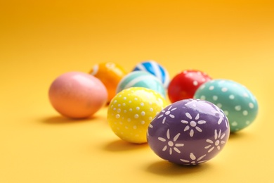 Photo of Painted Easter eggs on color background, space for text