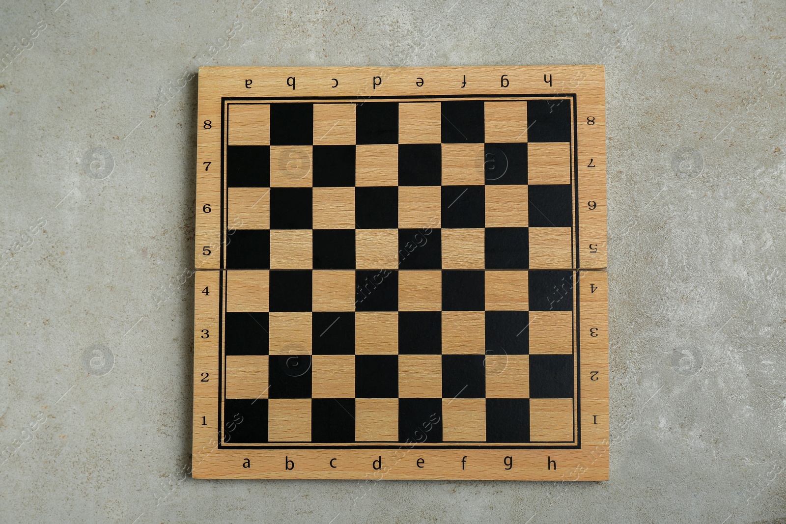 Photo of Empty wooden checkerboard on light grey table, top view