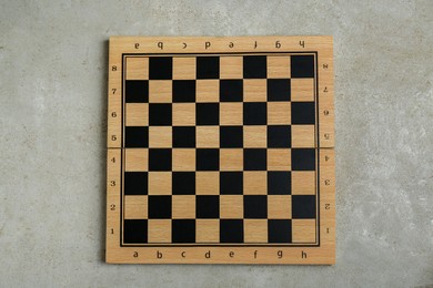 Photo of Empty wooden checkerboard on light grey table, top view