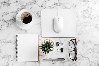 Flat lay composition with mouse and cup of coffee on white marble table
