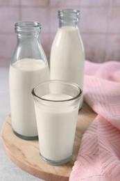 Glassware with tasty milk on table, closeup