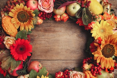 Photo of Beautiful autumnal wreath with flowers, berries and fruits on wooden background, closeup. Space for text