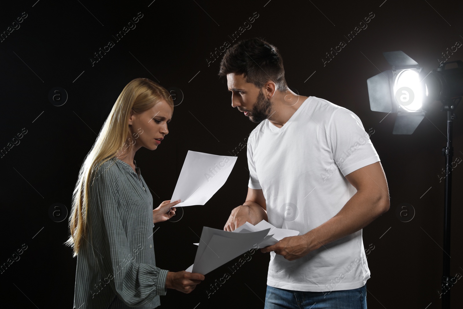 Photo of Professional actors reading their scripts during rehearsal in theatre