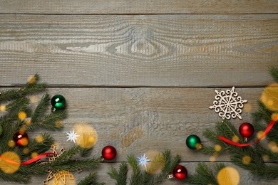 Photo of Christmas greeting card with space for text. Flat lay composition of fir tree branches and festive decor on wooden background