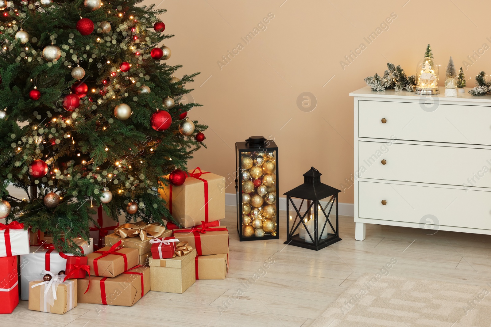 Photo of Beautiful tree decorated for Christmas and gift boxes in room. Interior design