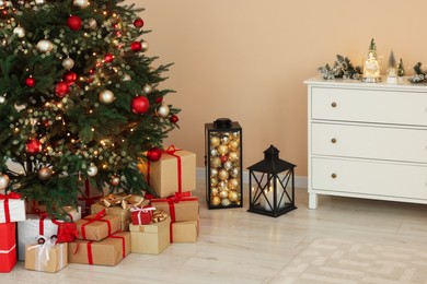 Photo of Beautiful tree decorated for Christmas and gift boxes in room. Interior design