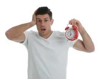 Photo of Emotional man with alarm clock on white background. Being late because of oversleeping