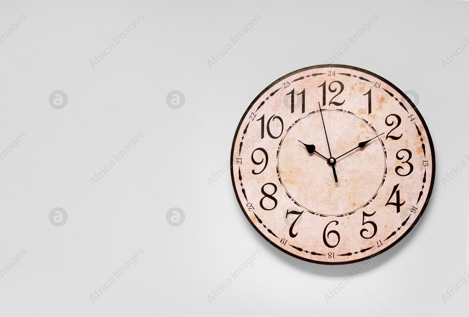 Photo of Stylish round clock on white background, top view with space for text. Interior element