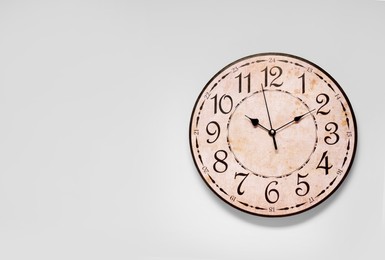 Photo of Stylish round clock on white background, top view with space for text. Interior element
