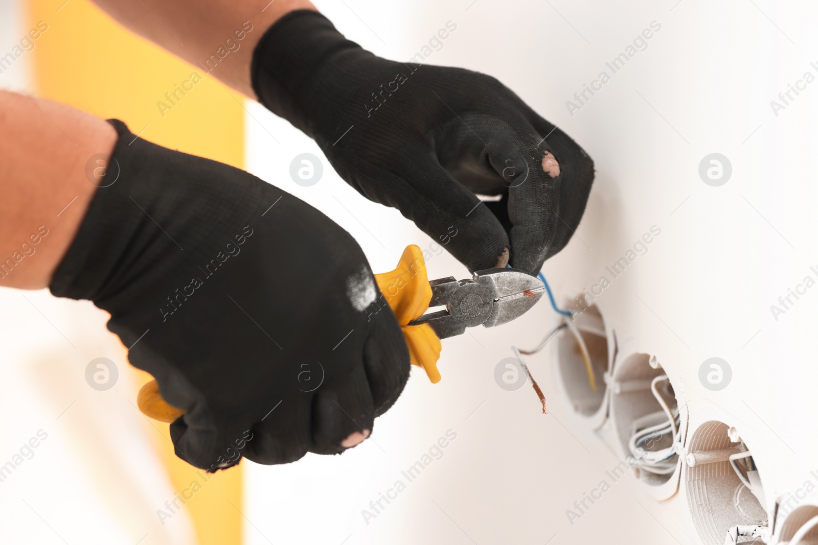 Photo of Handyman installing sockets in white wall, closeup