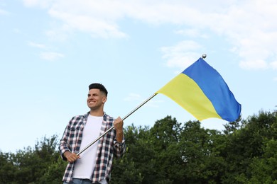 Man with national flag of Ukraine outdoors