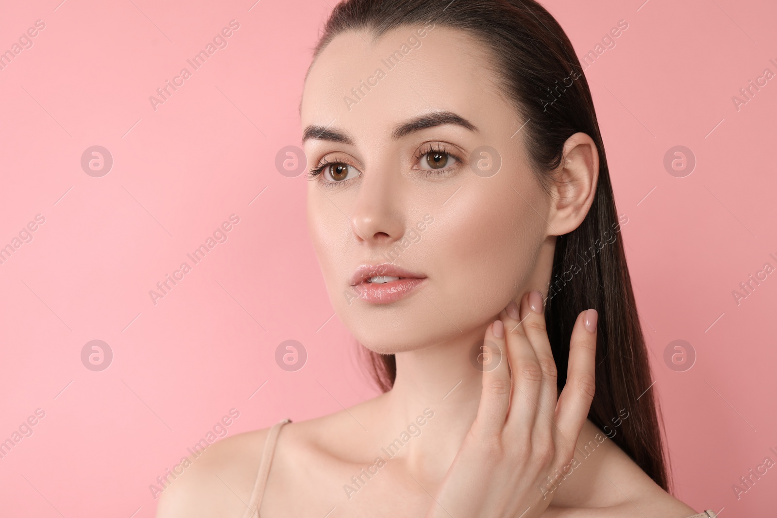 Photo of Portrait of beautiful young woman on pink background. Space for text