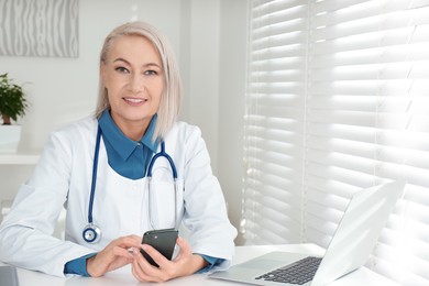 Photo of Portrait of mature female doctor in white coat at workplace