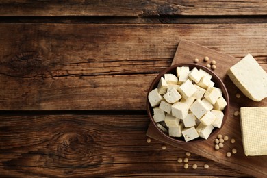 Photo of Cut tofu and soya beans on wooden table, flat lay. Space for text